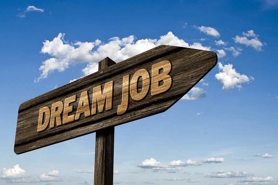 wooden sign saying Dream Job in a blue sky with clouds