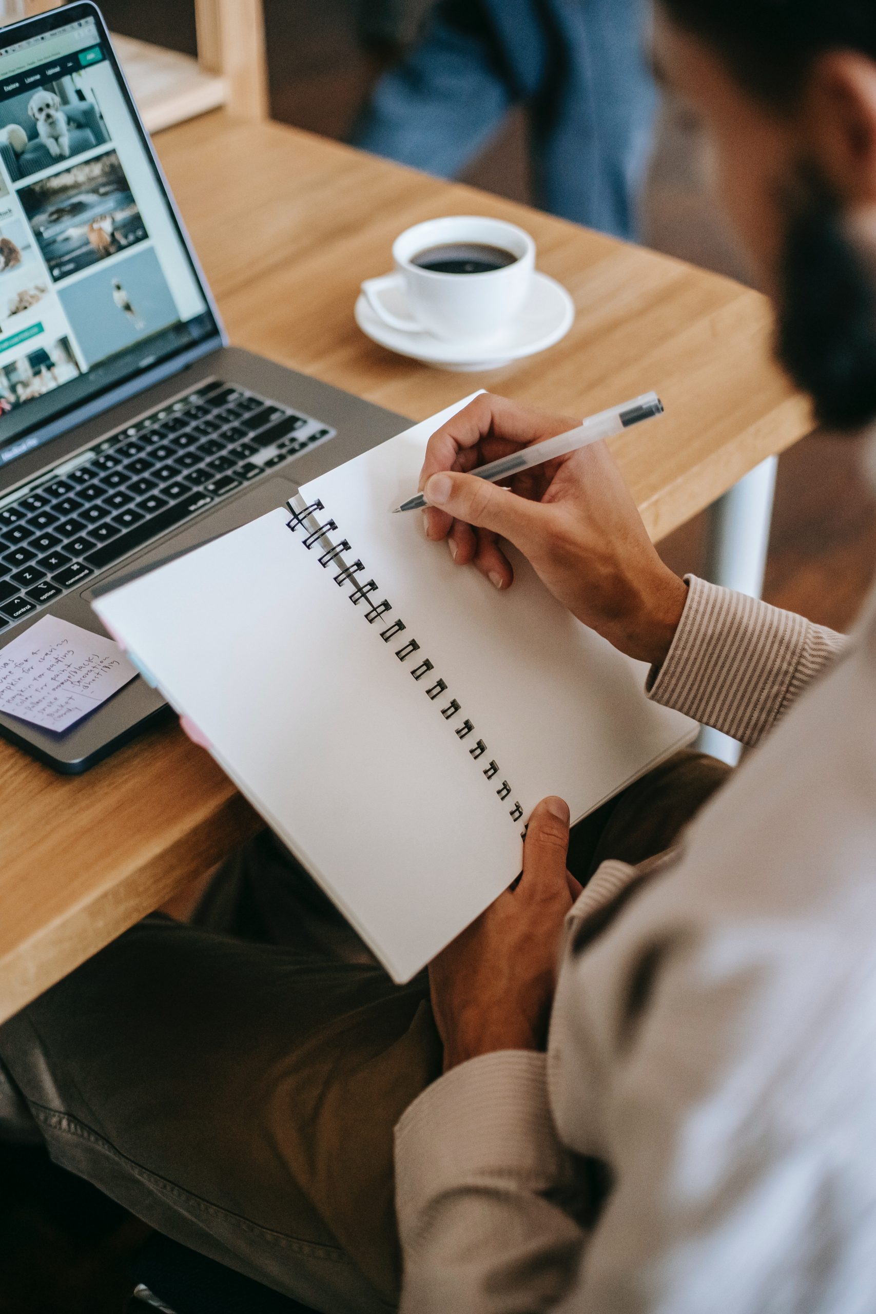 person-holding-pen-writing-on-a-notebook